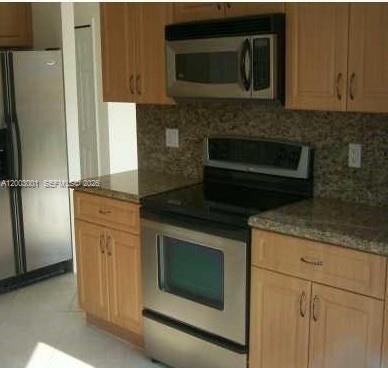 A kitchen features light wood cabinets, stainless steel appliances, and speckled granite countertops — 1955 NE 36th Ave # 0, Homestead FL 33033, HOMESTEAD, FL
