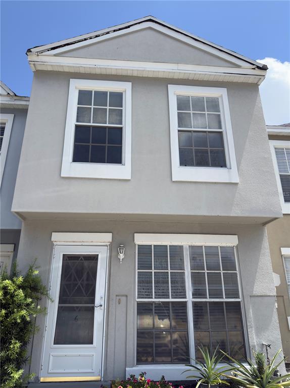 A two-story gray townhouse features a front door with a storm door and large windows — 6630 121ST AVENUE UNIT 6, LARGO, FL