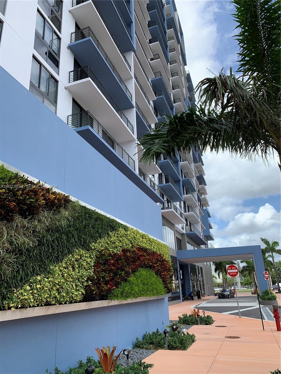 A multi-story apartment building features a blue exterior wall with a large vertical garden — 5350 NW 84 Ave # 1601, Doral FL 33166, DORAL, FL