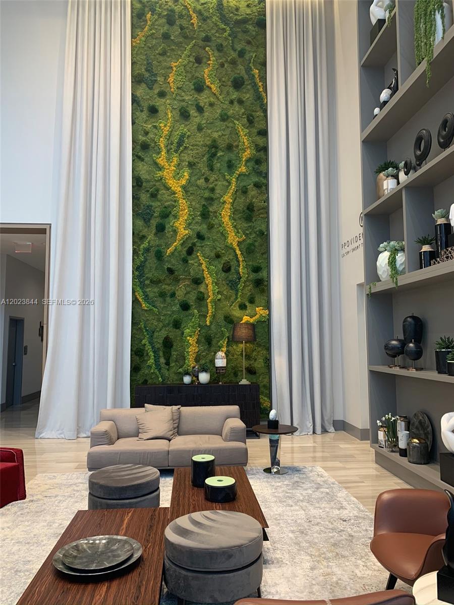 A living room features a tall moss wall, floor-to-ceiling curtains, and built-in shelving — 5350 NW 84 Ave # 1601, Doral FL 33166, DORAL, FL