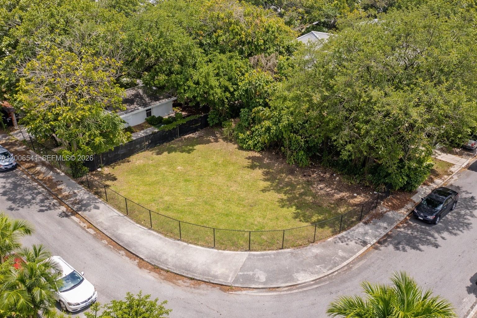 An aerial view shows a vacant corner lot enclosed by a black chain-link fence — 94 NE 56th St, Miami FL 33137, MIAMI, FL