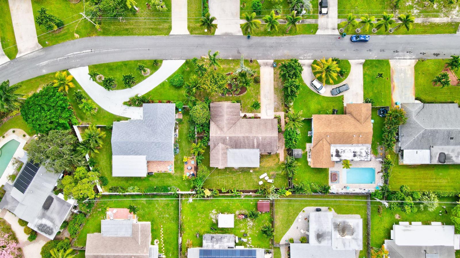 An aerial view shows several suburban houses with swimming pools, driveways, and lush green lawns — 1036 Coral Drive, Boynton Beach FL 33426, BOYNTON BEACH, FL