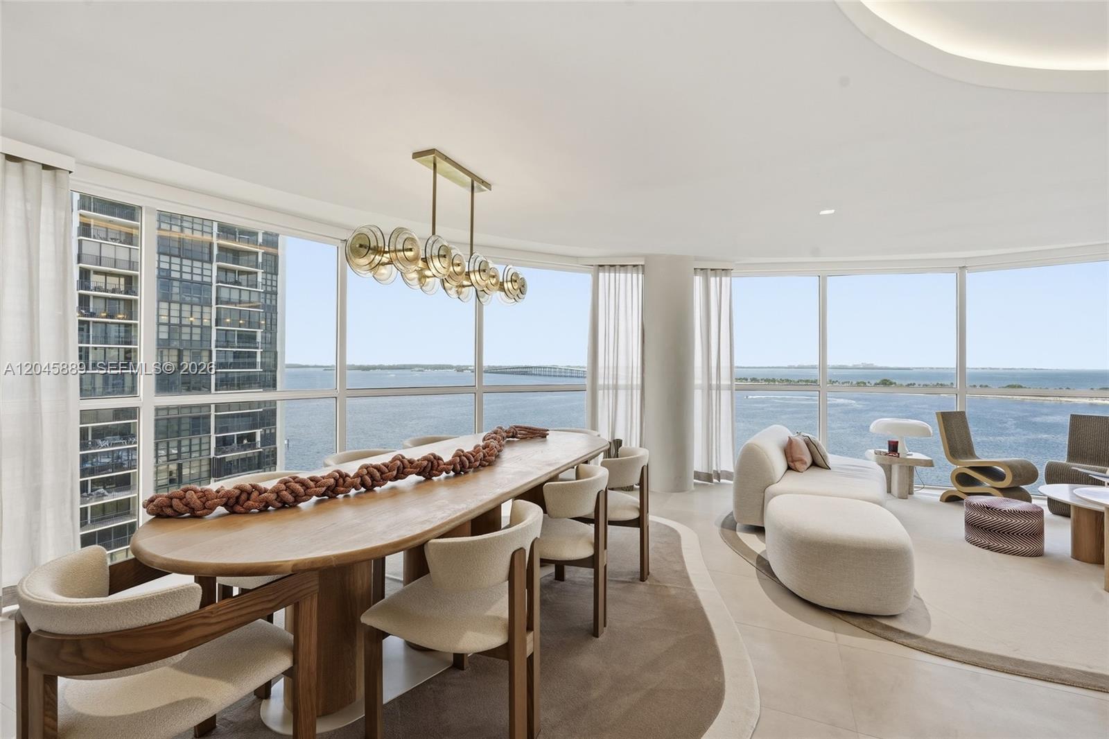 A dining and living area features floor-to-ceiling windows with expansive water views — 2025 Brickell Ave # 1401, Miami FL 33129, MIAMI, FL