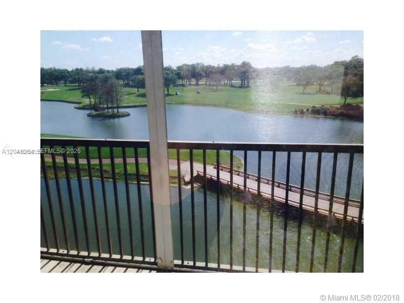 A balcony overlooks a lake, a wooden footbridge, and a golf course — 3001 W Rolling Hills Cir # 701, Davie FL 33328, DAVIE, FL