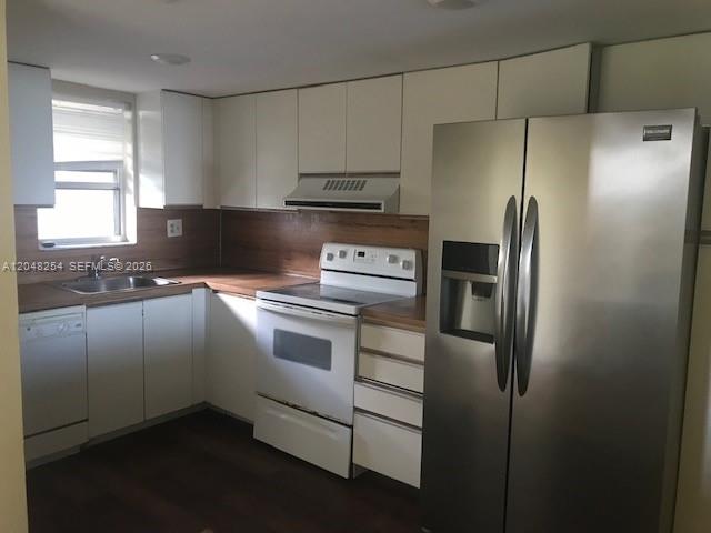 A kitchen features white cabinets, stainless steel appliances, and wood-look flooring — 3001 W Rolling Hills Cir # 701, Davie FL 33328, DAVIE, FL