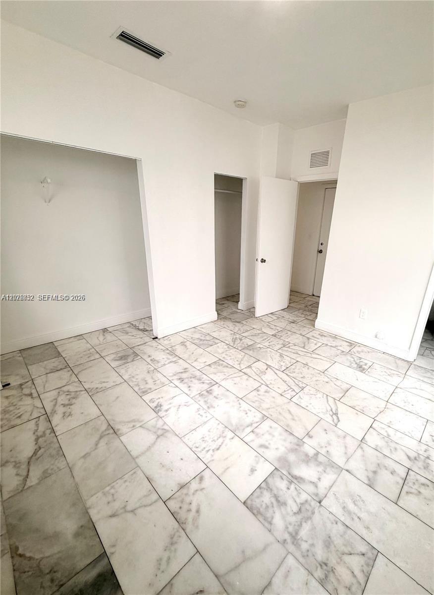 An empty room features white walls, a closet, and light-colored marble tile flooring — 922 Jefferson Ave # 6, Miami Beach FL 33139, MIAMI BEACH, FL