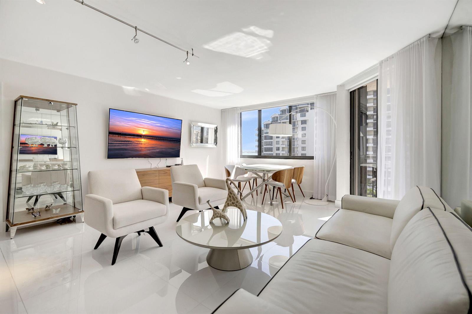 A bright living room features white tile floors, a glass coffee table, and a dining area — 540 Brickell Key Drive # 919, Miami FL 33131, MIAMI, FL