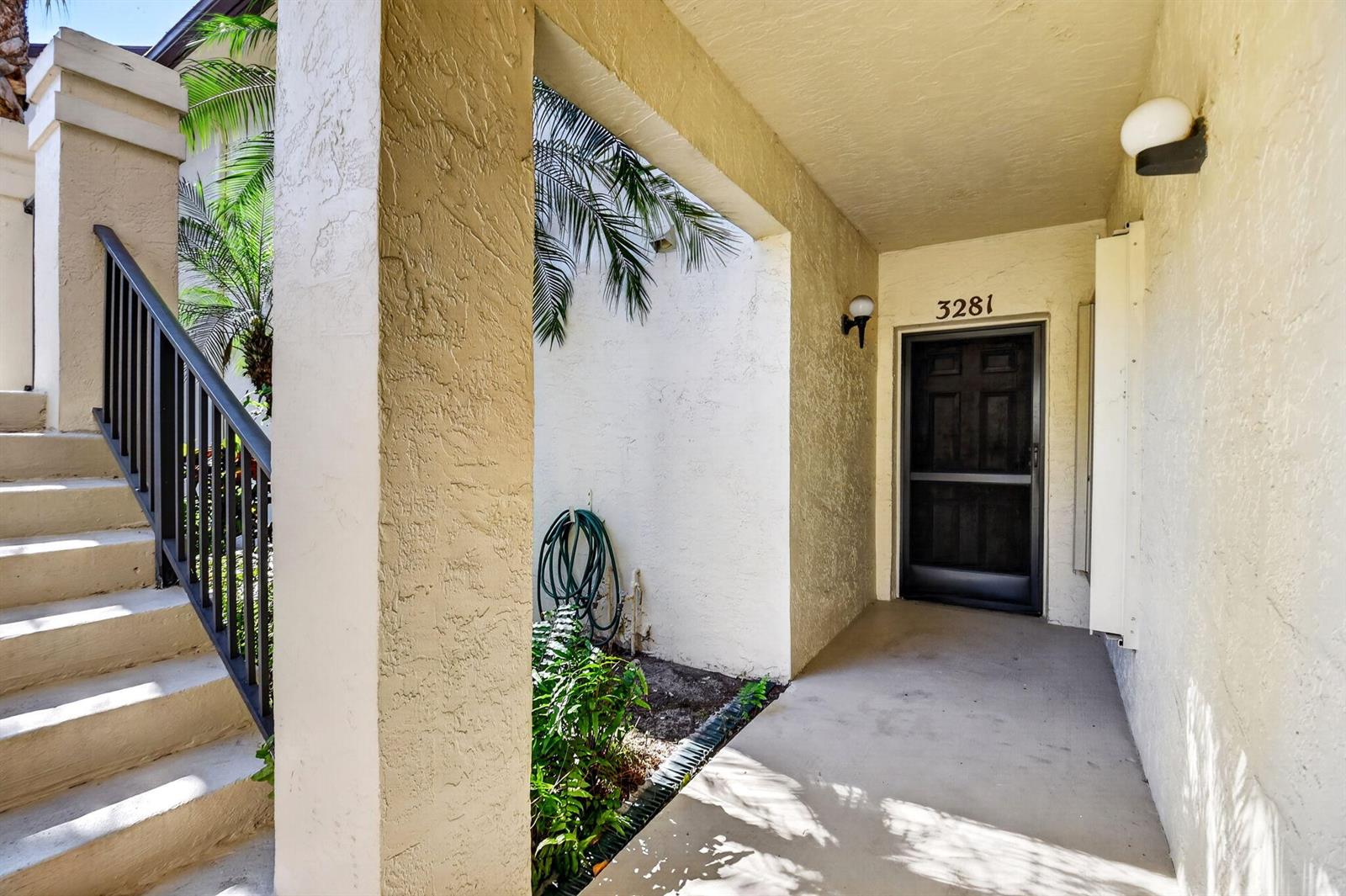 An exterior view of a residential building entrance with stairs, a walkway, and a door — 3281 Jog Park Drive, FL 33467, FL