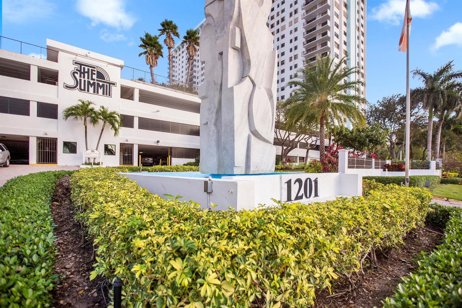 A large abstract sculpture stands in front of a multi-story building labeled The Summit — 1201 S Ocean Drive # 2509s, Hollywood FL 33019, HOLLYWOOD, FL