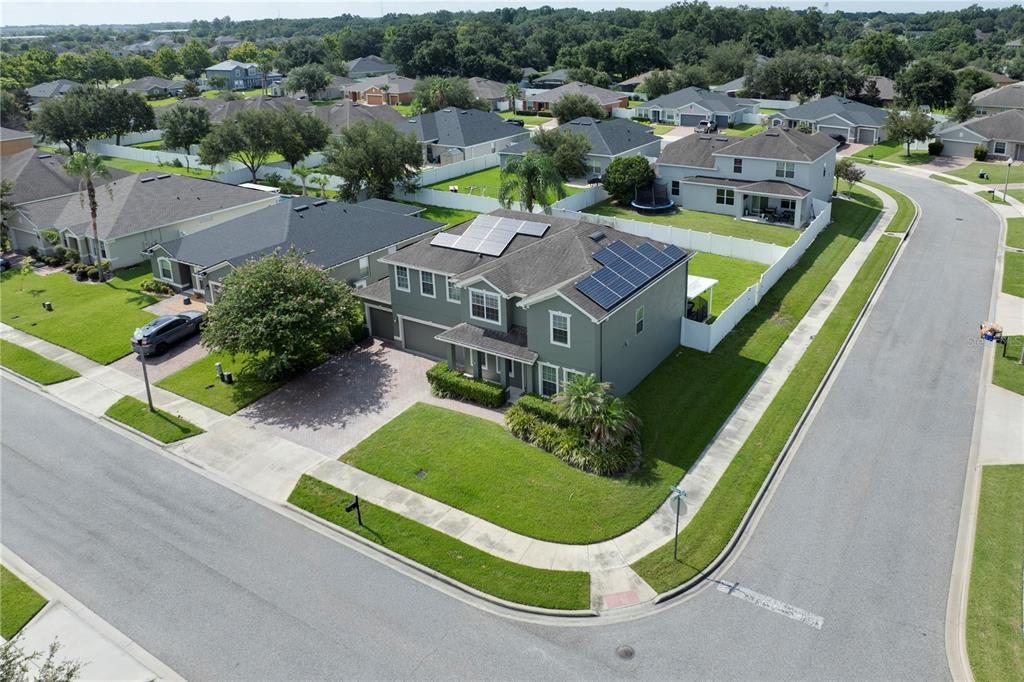 An aerial view shows a two-story house with solar panels on a corner lot — 637 GRASSY STONE DRIVE, WINTER GARDEN, FL