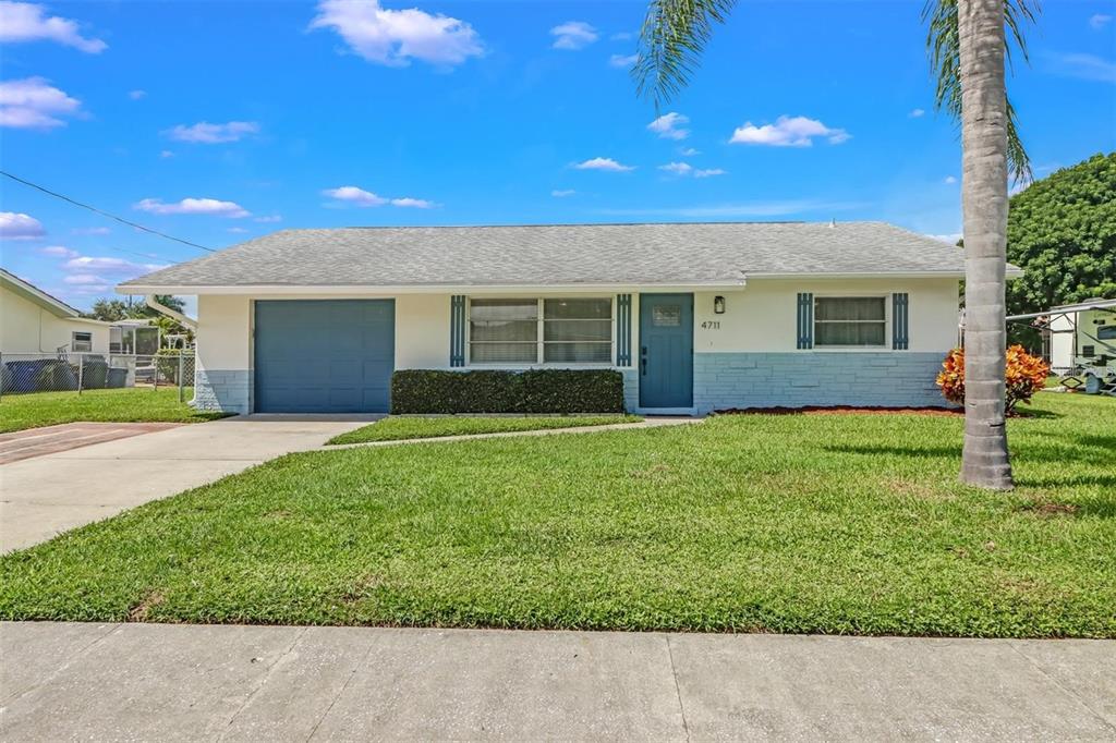 A single-story house with a blue garage door, blue front door, and a front lawn — 4711 FOREST GLEN DRIVE, NORTH FORT MYERS, FL