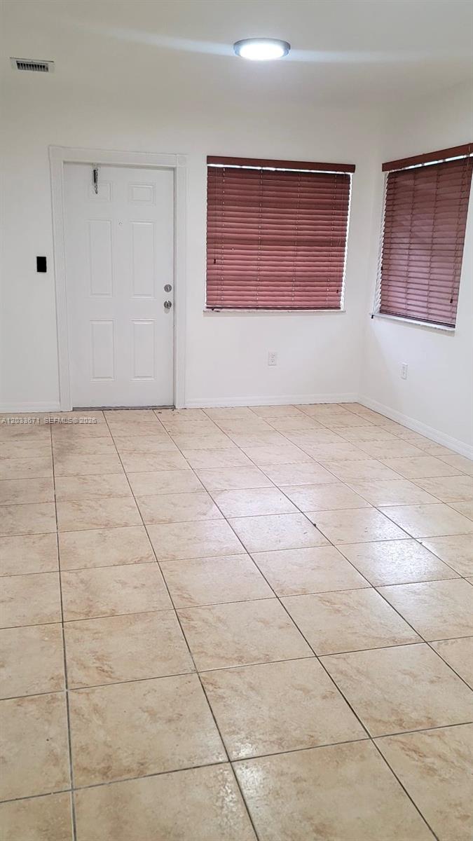 A kitchen features white cabinets, a marble-patterned countertop, a stainless steel sink, and tile flooring — 3250 NW 94 ST # 0, Miami FL 33147, MIAMI, FL