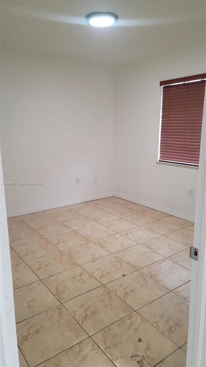 A kitchen features a stainless steel refrigerator, a black electric stove, and white cabinets — 3250 NW 94 ST # 0, Miami FL 33147, MIAMI, FL