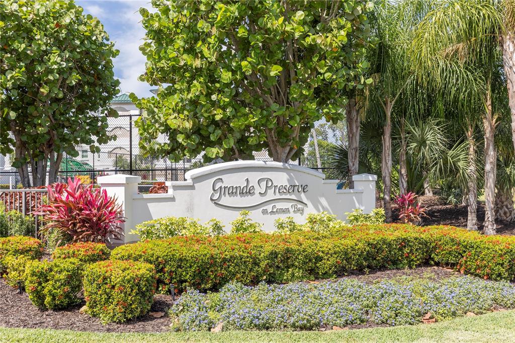 A stone monument sign for Grande Preserve on Lemon Bay sits amidst lush tropical landscaping — 9203 GRIGGS ROAD UNIT D302, ENGLEWOOD, FL