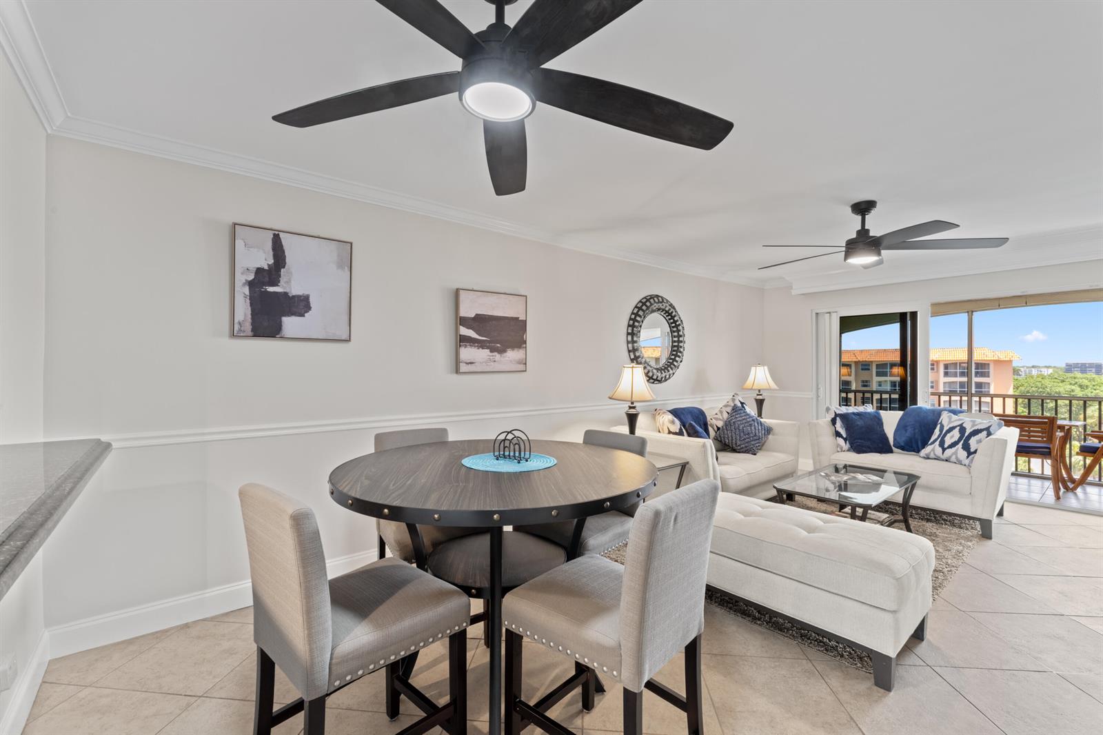 A dining area and living room feature tile floors, ceiling fans, and a balcony view — 2871 N Ocean Boulevard # M538, Boca Raton FL 33431, BOCA RATON, FL