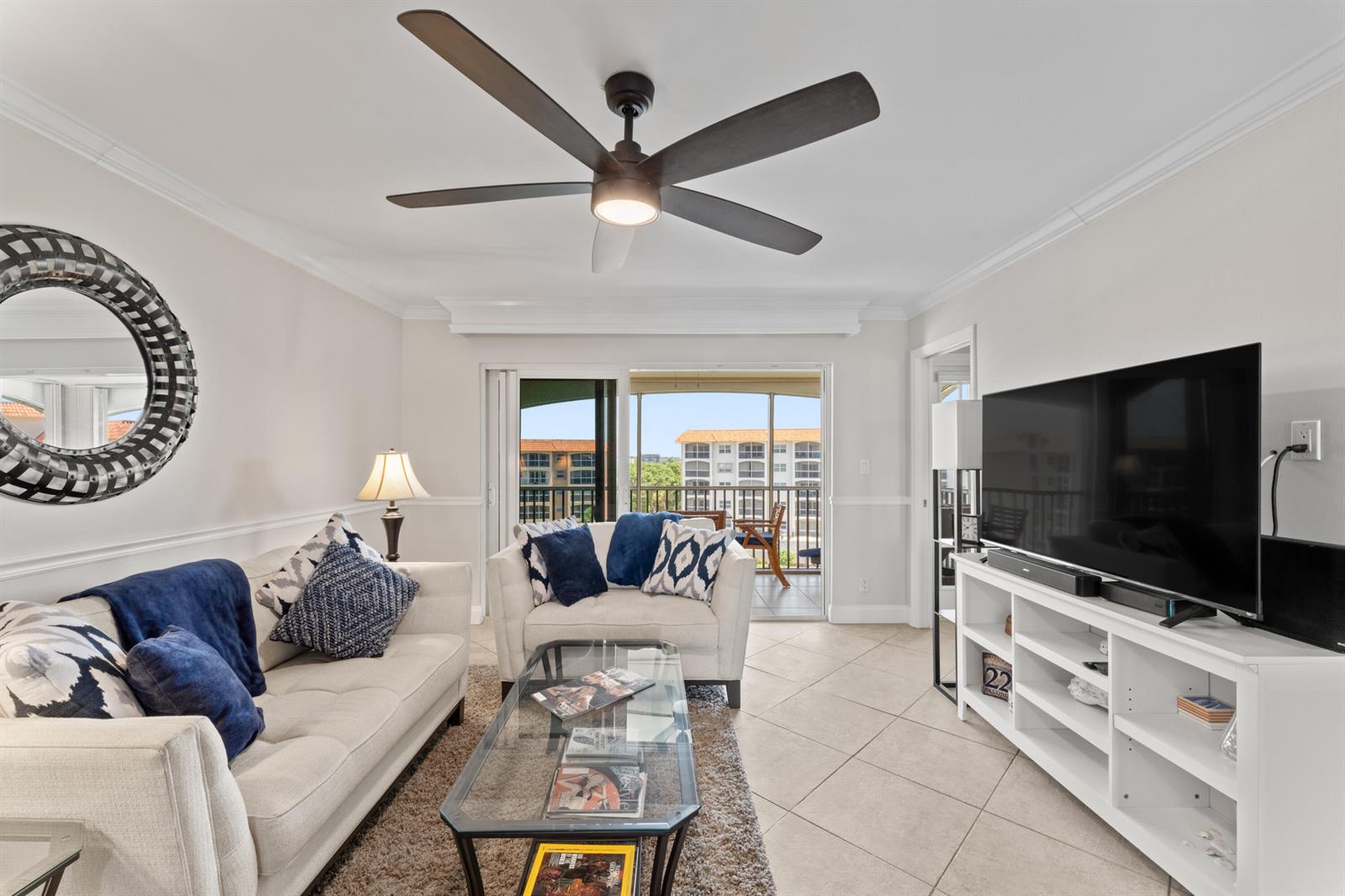 A living room with a sofa, armchair, glass coffee table, and a balcony view — 2871 N Ocean Boulevard # M538, Boca Raton FL 33431, BOCA RATON, FL