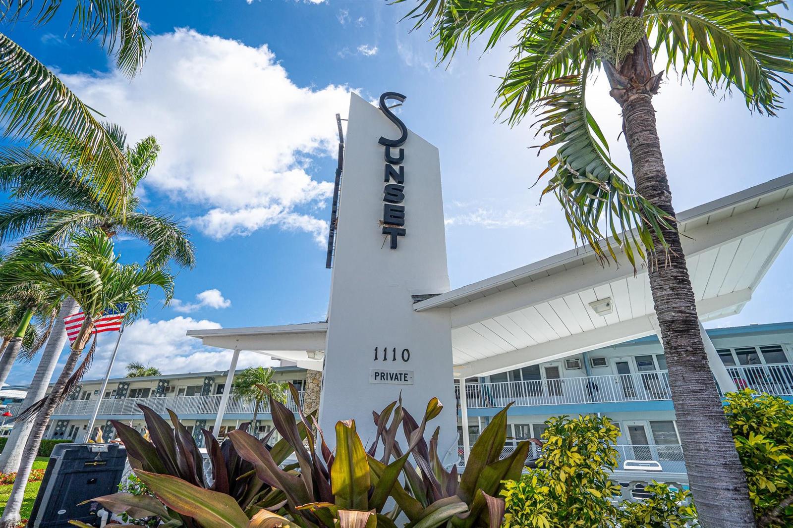 A white sign with the word Sunset stands in front of a multi-story motel building — 1110 N Riverside Drive # 20, Pompano Beach FL 33062, POMPANO BEACH, FL