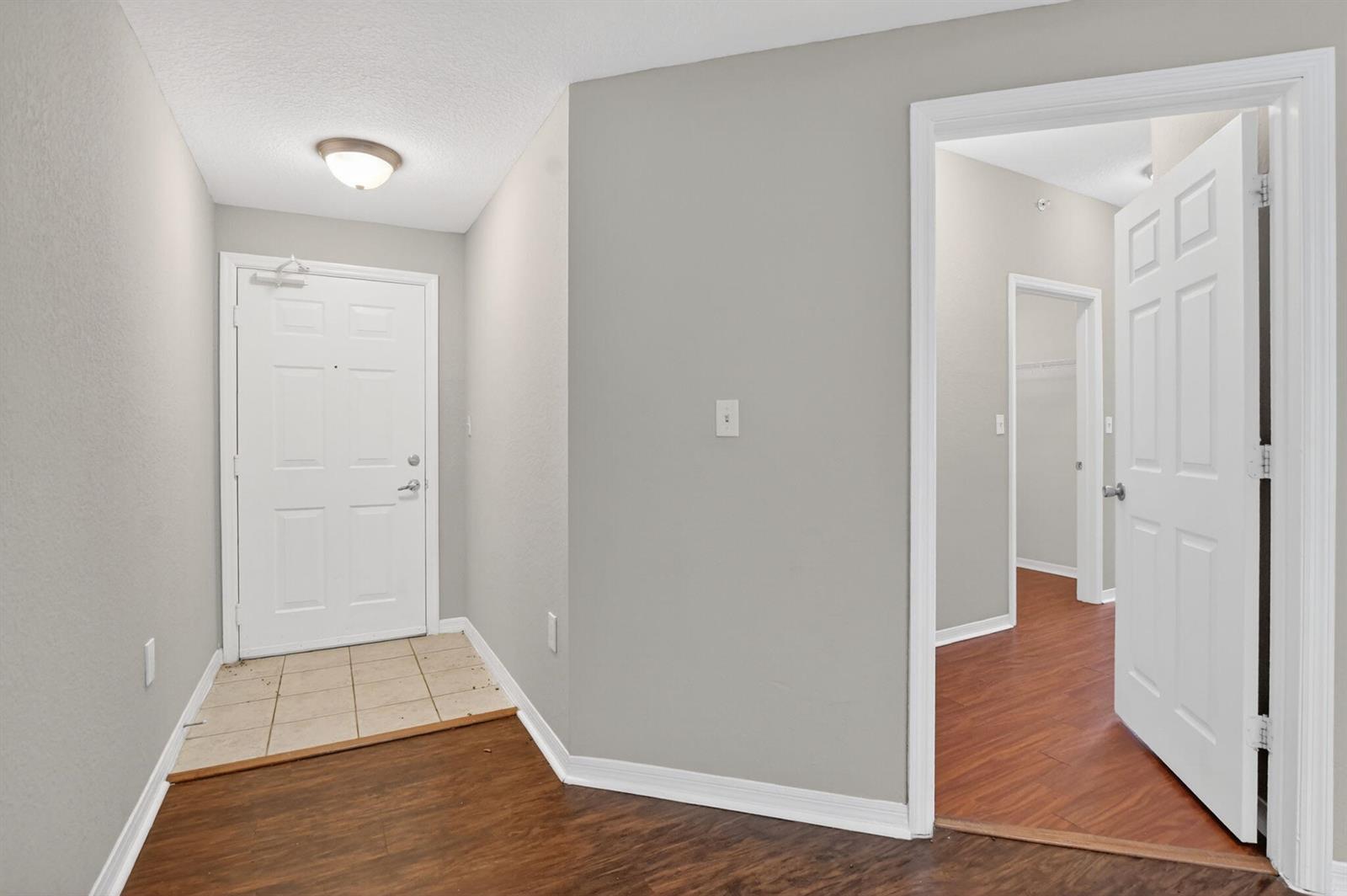 An entryway with a tiled floor, a white front door, and a doorway leading inside — 15085 Michelangelo Boulevard # 105, Delray Beach FL 33446, DELRAY BEACH, FL