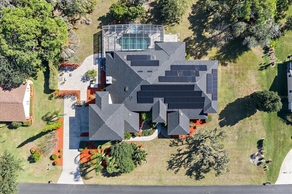 An aerial view shows a house with a solar panel array and a screened pool — 3416 SUNRISE DRIVE, SEBRING, FL