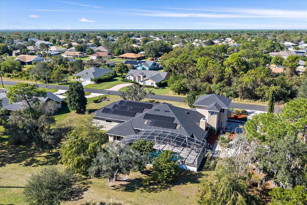 An aerial view of a suburban house with a screened pool and solar panels — 3416 SUNRISE DRIVE, SEBRING, FL
