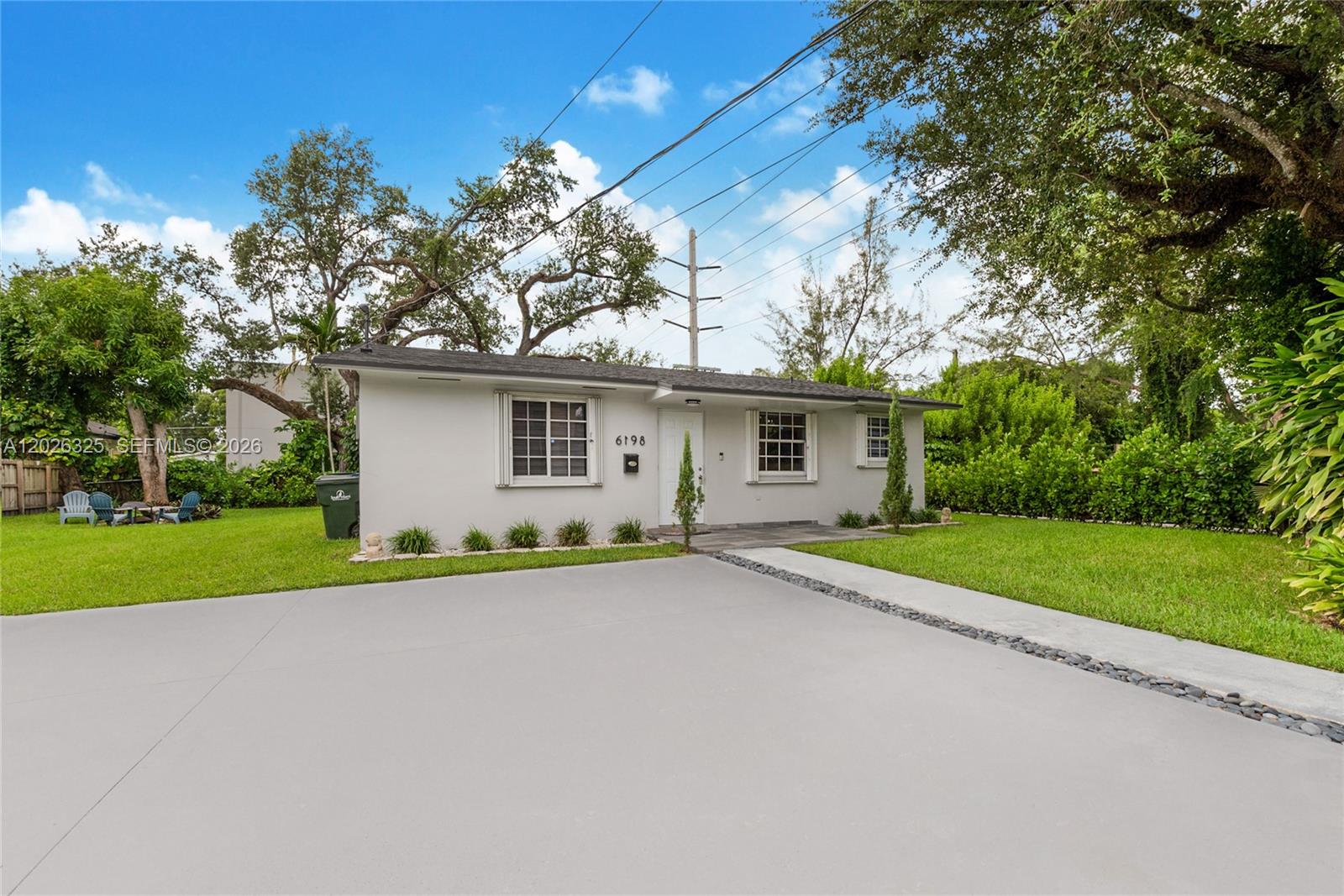A single-story house with a white exterior, a gray roof, and a paved driveway — 6198 SW 63rd St, South Miami FL 33143, SOUTH MIAMI, FL