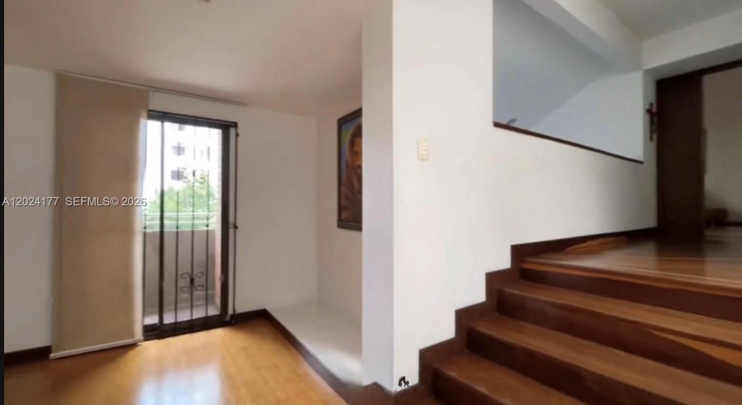 A room with hardwood floors and a staircase leading to an upper level — 17 # 7- 120 Carrera, FL 0000, FL