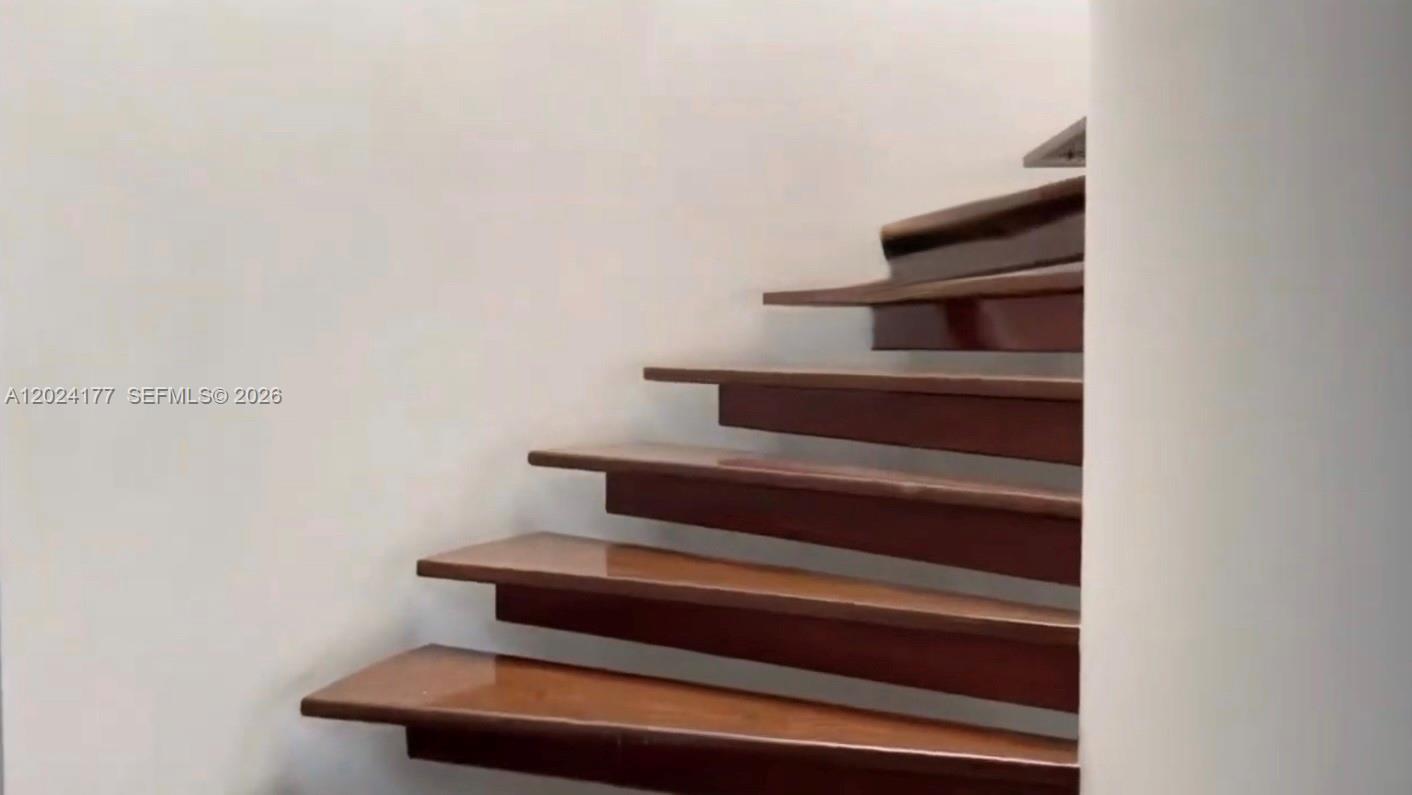 A staircase with wooden floating treads ascends against a plain white wall — 17 # 7- 120 Carrera, FL 0000, FL