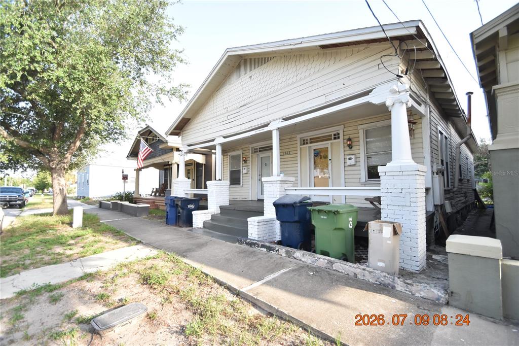 A single-story house with a front porch, white columns, and trash bins on the sidewalk — 1908 E 15TH AVENUE UNIT A, TAMPA, FL