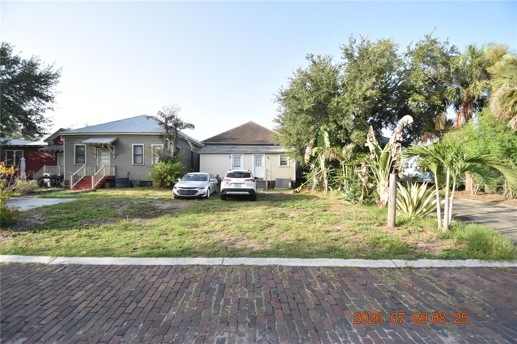 Two houses sit behind a grassy yard and a brick street — 1908 E 15TH AVENUE UNIT A, TAMPA, FL