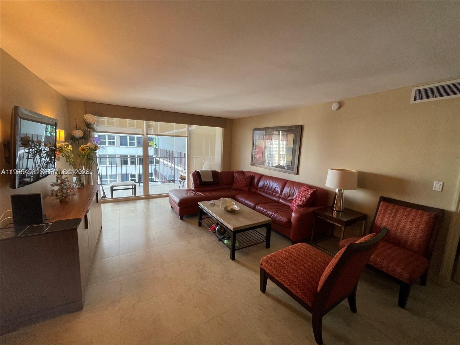 A living room features a red leather sectional, two patterned chairs, and a balcony view — 2030 S Ocean Dr # 1404, Hallandale Beach FL 33009, HALLANDALE BEACH, FL