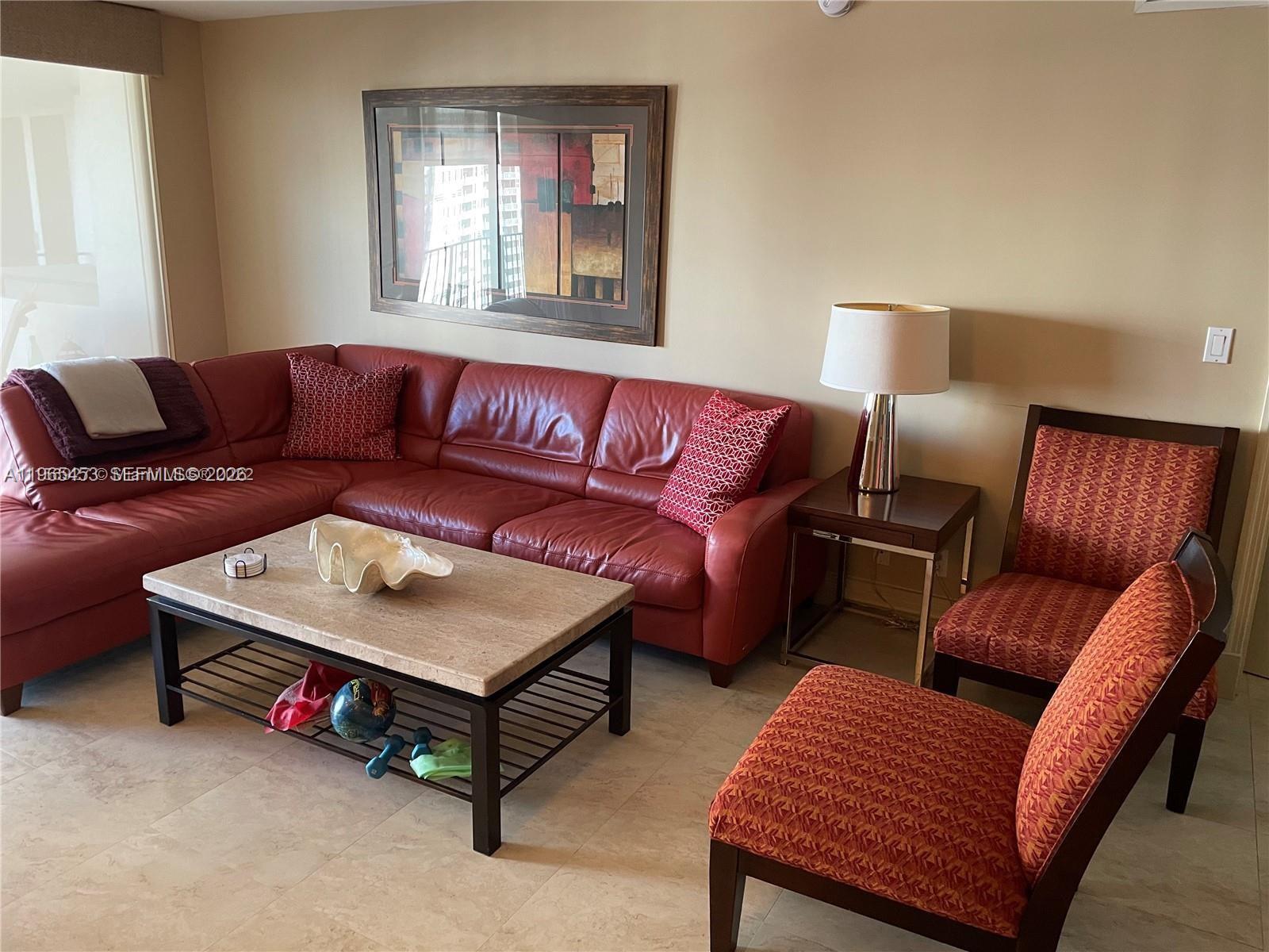 A living room features a red leather sectional, two patterned chairs, and a stone coffee table — 2030 S Ocean Dr # 1404, Hallandale Beach FL 33009, HALLANDALE BEACH, FL