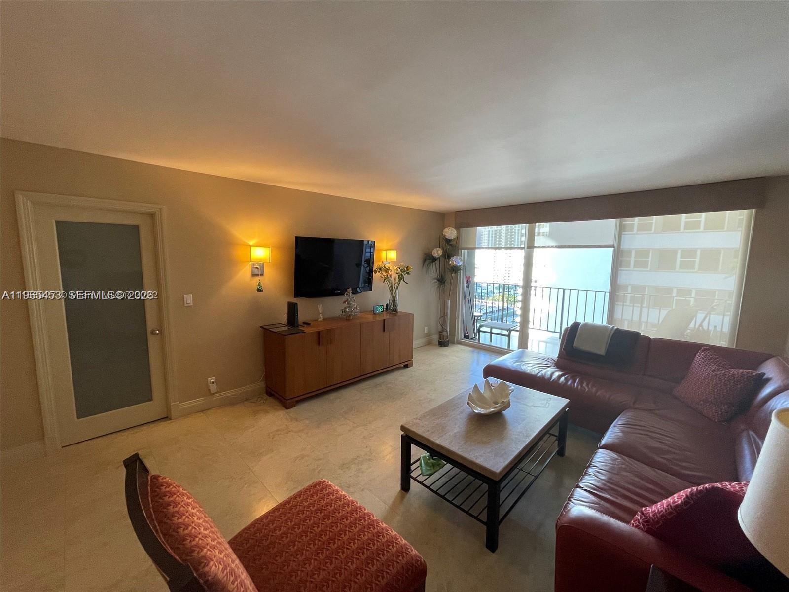 A living room features a red leather sectional, a wooden console, and a balcony view — 2030 S Ocean Dr # 1404, Hallandale Beach FL 33009, HALLANDALE BEACH, FL