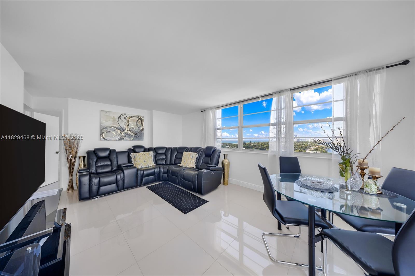 A living and dining area features white tile floors, a black sectional, and large windows — 3161 S Ocean Dr # 1510, Hallandale Beach FL 33009, HALLANDALE BEACH, FL