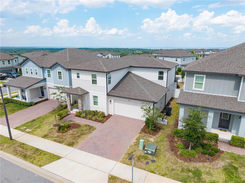 An aerial view of a two-story suburban house with a brick driveway and garage — 2326 RAVEN RIDGE ROAD, MINNEOLA, FL