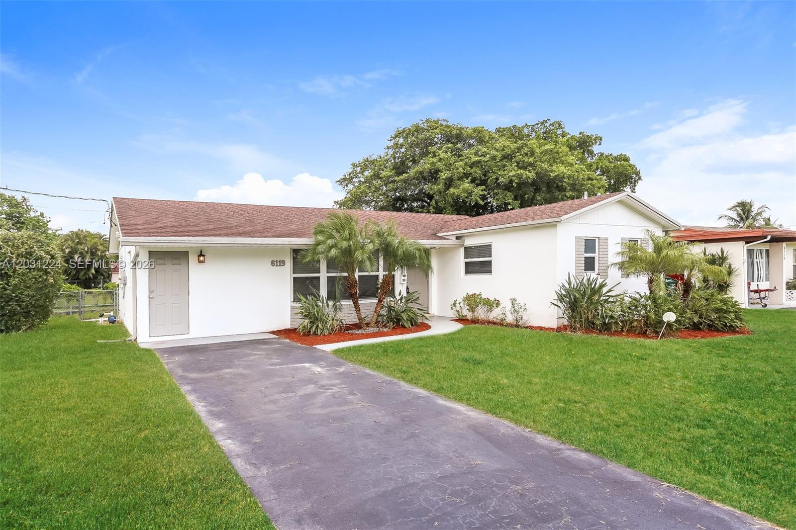 A white single-story house features a brown shingled roof, a driveway, and front landscaping — 6119 NW 18th Ct, Margate FL 33063, MARGATE, FL