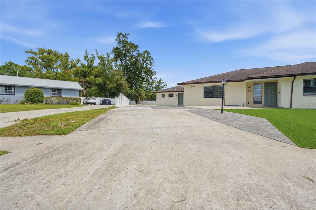 A concrete driveway leads to a single-story house with a paved walkway and green lawn — 1433 ELLISON LANE, LAKELAND, FL