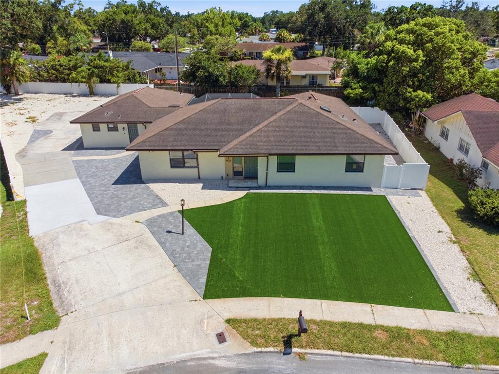 An aerial view shows a single-story house with a brown roof, artificial lawn, and driveway — 1433 ELLISON LANE, LAKELAND, FL