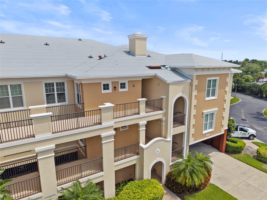An exterior view of a multi-story apartment building with balconies and a gray roof — 10 FRANKLIN COURT S UNIT 63C, ST PETERSBURG, FL