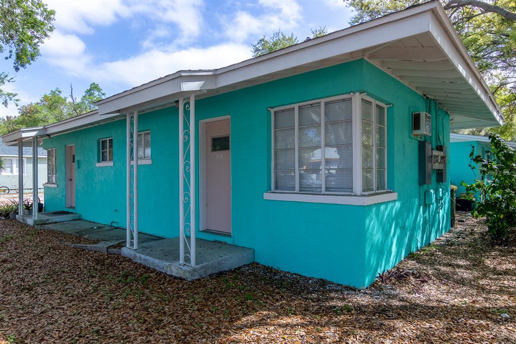 A bright turquoise single-story house features a covered porch with decorative white metal supports — 610 N EAST AVENUE, SARASOTA, FL