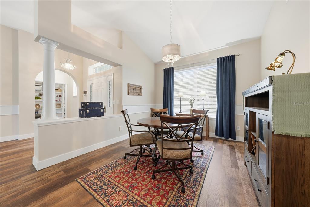 A dining area features a round wooden table, four chairs, and a patterned area rug — 2360 PARK FOREST BOULEVARD, MOUNT DORA, FL