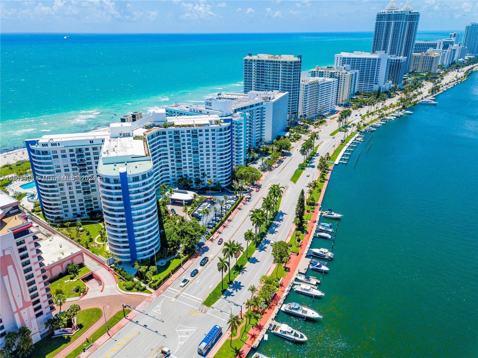 An aerial view shows high-rise buildings along a coastal road with a boat-lined waterway — 5161 Collins Ave # 405, Miami Beach FL 33140, MIAMI BEACH, FL