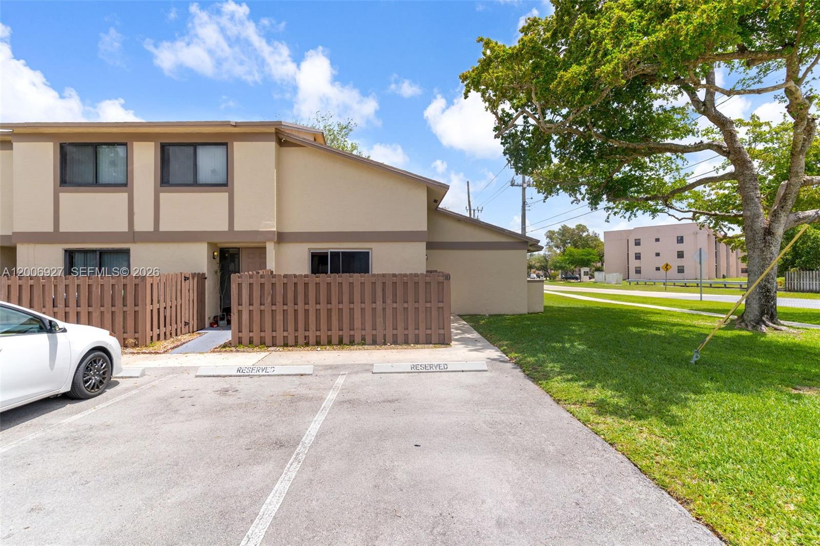 A two-story tan townhouse features a wooden privacy fence and two reserved parking spaces — 2950 NW 106th ave # 10, Sunrise FL 33322, SUNRISE, FL