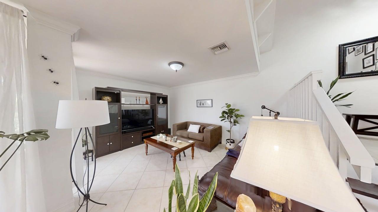 A living room features tile flooring, a dark wood entertainment center, and a brown sofa — 5803 Fox Hollow Drive # B, Boca Raton FL 33486, BOCA RATON, FL