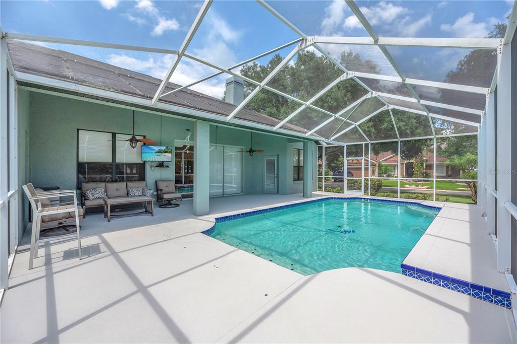 A covered patio with a swimming pool enclosed by a screen cage — 2219 LONGMORE CIRCLE, VALRICO, FL