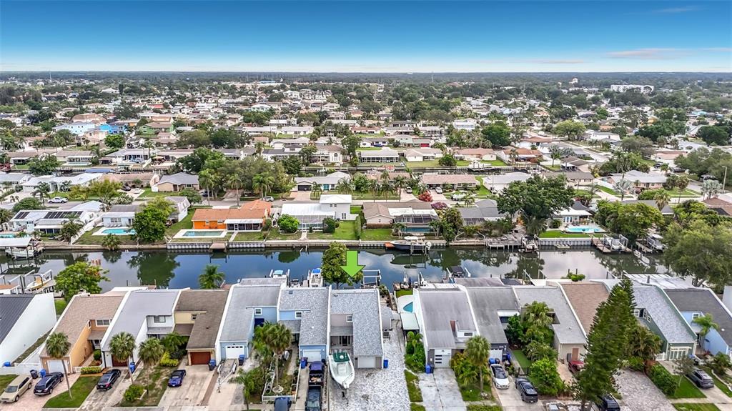 An aerial view shows a row of waterfront townhouses with private docks along a canal — 8725 BAY POINTE DRIVE, TAMPA, FL