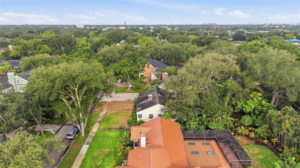An aerial view shows a house with a metal roof and a screened-in pool area — 3123 W OAKLYN AVENUE, TAMPA, FL