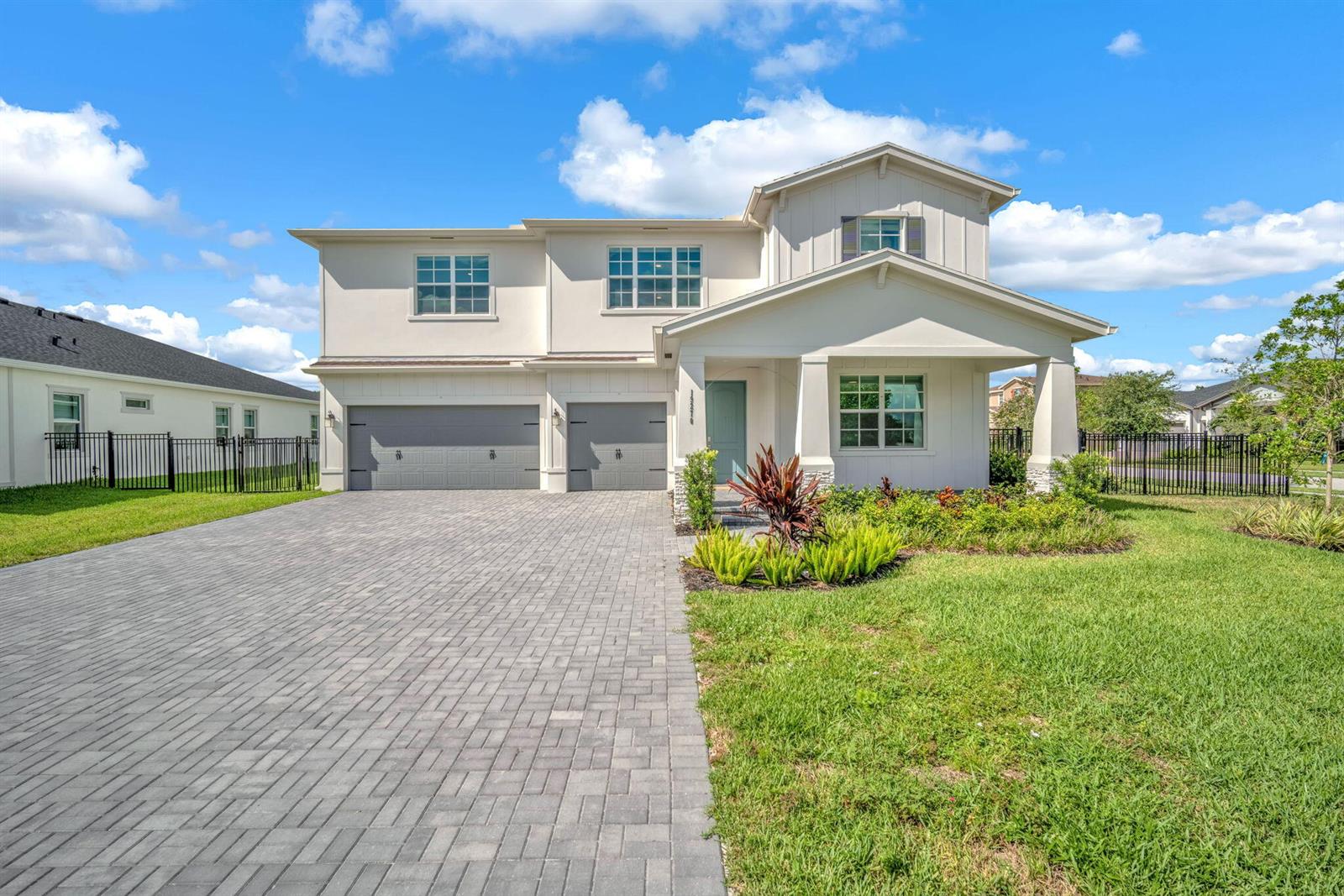 A two-story house with a paved driveway, two-car garage, and a covered front porch — 19270 Rolling Acres Road, FL 33470, FL