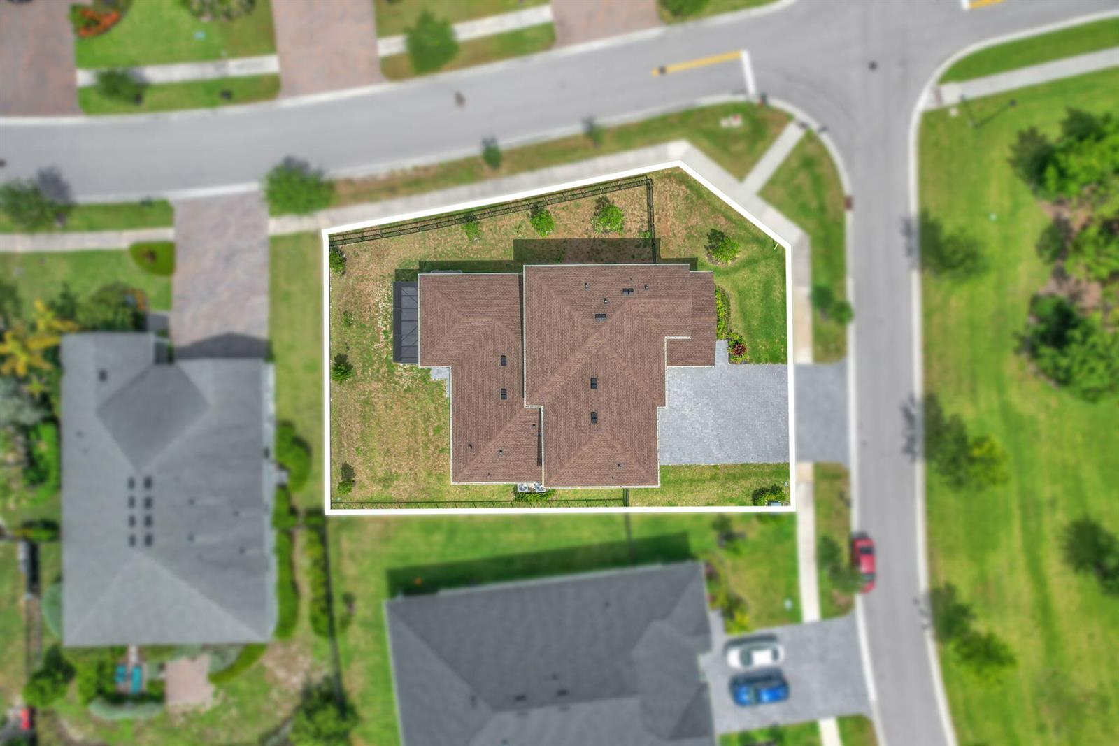 An aerial view shows a single-family home with a fenced backyard on a corner lot — 19270 Rolling Acres Road, FL 33470, FL