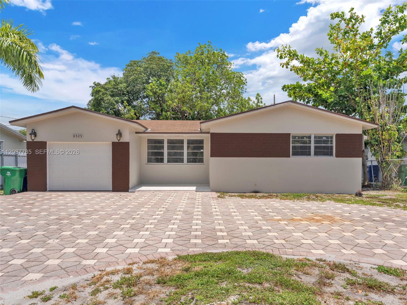 A single-story house features a paved driveway, a garage, and a brown and beige exterior — 6525 SW 18th St, Miramar FL 33023, MIRAMAR, FL