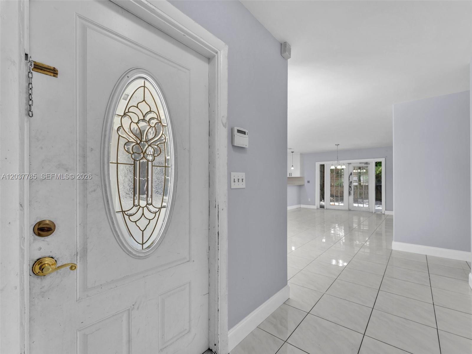 A white front door with an oval glass insert opens into a tiled living area — 6525 SW 18th St, Miramar FL 33023, MIRAMAR, FL